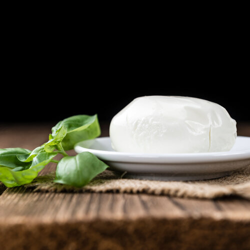 Mozzarella auf Holz liegend mit dunklem Hintergrund 