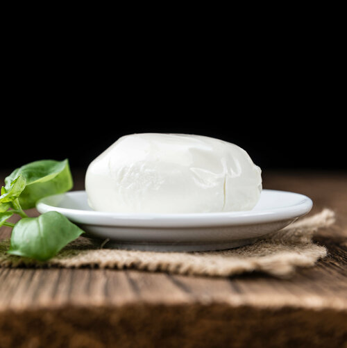 Mozzarella auf Holz liegend mit dunklem Hintergrund 