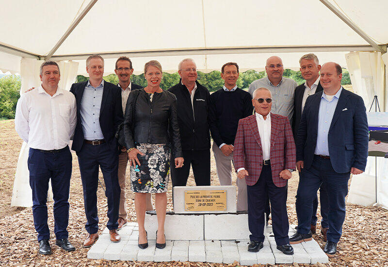 The image depicts the official groundbreaking ceremony for the expansion in Coulmer, France, on September 19. CEO Thomas Freis emphasizes the focus on the medical and pharmaceutical sectors.